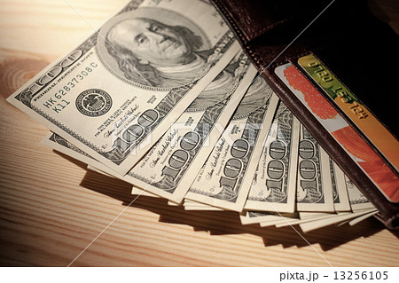 Brown Wallet with credit cards and dollar banknotes over wooden Brown Wallet with credit cards and dollar banknotes over wooden 13256105
