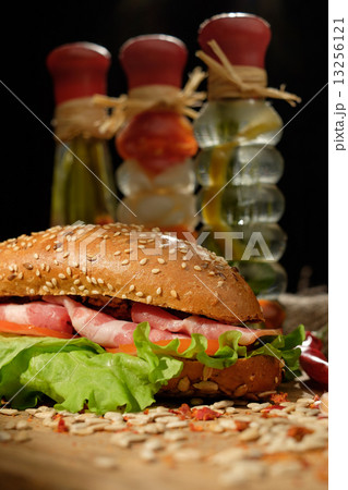 Sandwich on a wooden table with slices of bacon, lettuce and tom 13256121