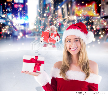 Composite image of pretty santa girl holding gift 13264099