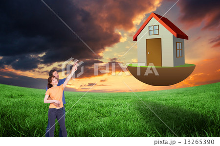 Composite image of happy couple pointing upwards together Composite image of happy couple pointing upwards together 13265390
