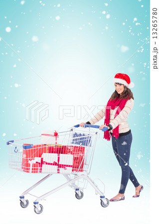 Composite image of brunette in santa hat with shopping trolley Composite image of brunette in santa hat with shopping trolley 13265780