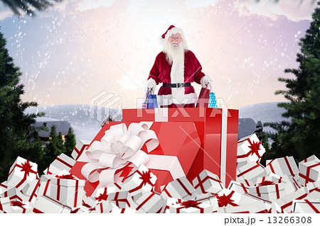 Composite image of santa standing in large gift Composite image of santa standing in large gift 13266308