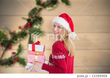 Composite image of woman holding christmas presents 13266908