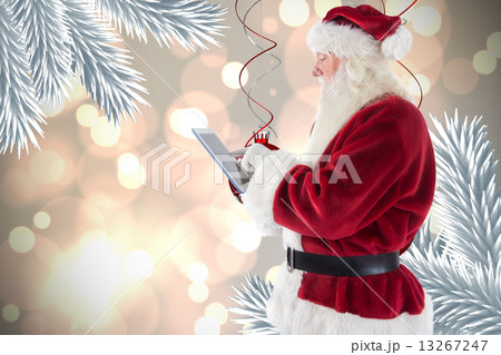 Composite image of santa uses a tablet pc 13267247