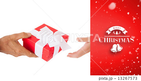 Composite image of couple passing a wrapped gift Composite image of couple passing a wrapped gift 13267573