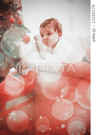 Composite image of cute baby boy on couch at christmas Composite image of cute baby boy on couch at christmas 13268178