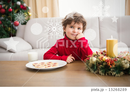 Composite image of festive little boy having milk and cookies 13268289