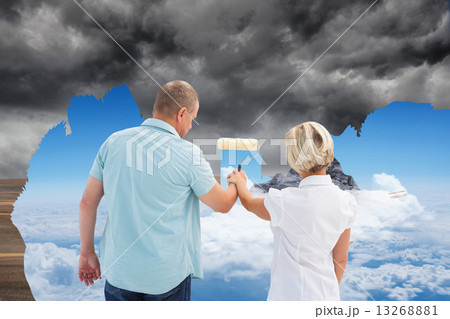 Composite image of happy older couple painting together 13268881