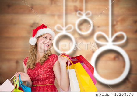 Composite image of smiling blonde in santa hat holding shopping Composite image of smiling blonde in santa hat holding shopping 13268976