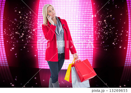 Composite image of happy blonde in winter clothes holding shoppi Composite image of happy blonde in winter clothes holding shoppi 13269655