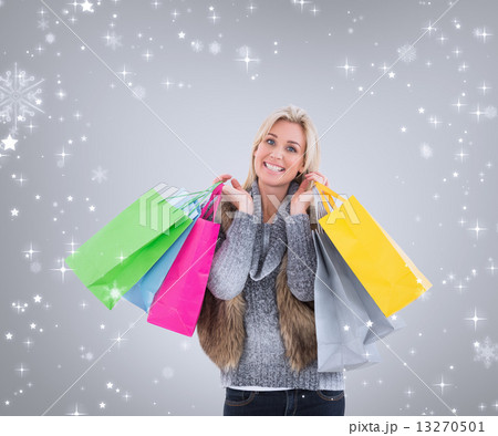 Composite image of blonde in winter clothes holding shopping bag Composite image of blonde in winter clothes holding shopping bag 13270501