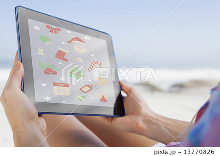Composite image of woman sitting on beach in deck chair using ta Composite image of woman sitting on beach in deck chair using ta 13270826