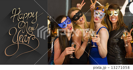 Composite image of attractive women wearing masks holding champa Composite image of attractive women wearing masks holding champa 13271058