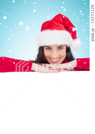 Composite image of beauty brunette in santa hat smiling at camer Composite image of beauty brunette in santa hat smiling at camer 13271126