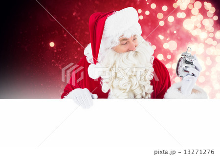 Composite image of happy santa holding alarm clock and sign 13271276
