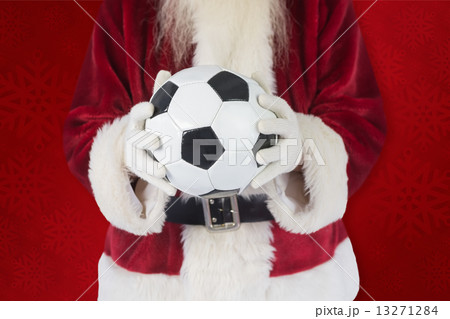 Composite image of santa holds a classic football 13271284