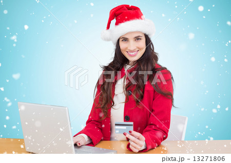 Composite image of festive brunette shopping online Composite image of festive brunette shopping online 13271806