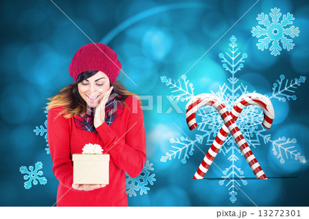 Composite image of surprised brunette holding a gift Composite image of surprised brunette holding a gift 13272301