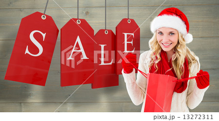 Composite image of happy festive blonde with shopping bag 13272311