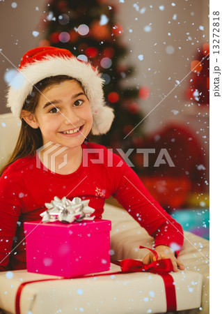 Composite image of festive little girl smiling at camera with gifts Composite image of festive little girl smiling at camera with gifts 13272818