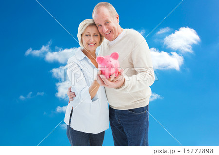 Composite image of happy mature couple smiling at camera showing 13272898