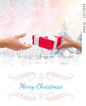 Composite image of couple passing a wrapped gift 13272934