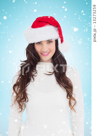 Composite image of beautiful brunette in santa hat smiling at ca Composite image of beautiful brunette in santa hat smiling at ca 13273259