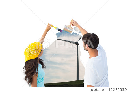 Composite image of happy young couple painting together 13273339