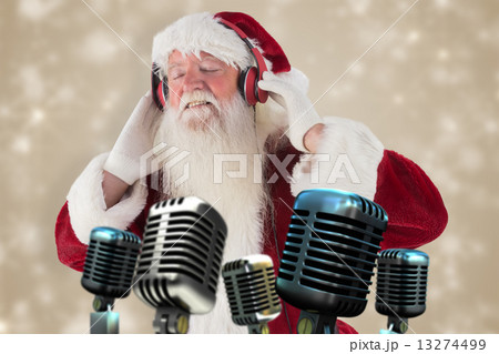 Composite image of santa claus enjoys some music Composite image of santa claus enjoys some music 13274499