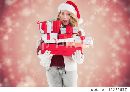 Composite image of blonde woman in trouble holding pile of gifts 13275637