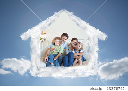 Composite image of smiling family watching tv together 13276742