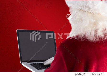 Composite image of santa claus uses a laptop 13276748