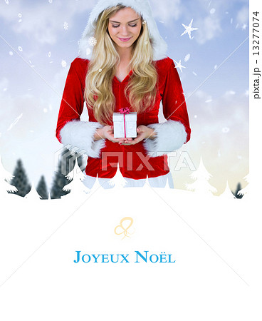 Composite image of pretty girl in santa outfit holding gift Composite image of pretty girl in santa outfit holding gift 13277074
