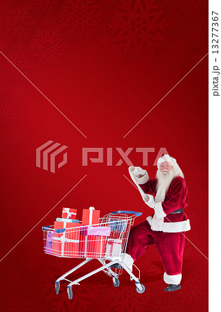 Composite image of santa pushes a shopping cart while reading 13277367