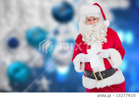 Composite image of happy santa holding paper and pen 13277610