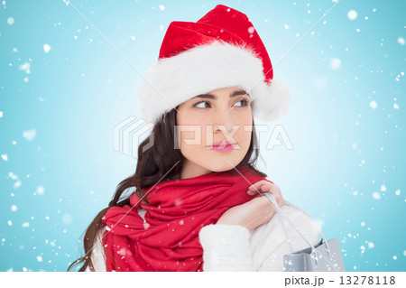 Composite image of brunette in santa hat holding shopping bag Composite image of brunette in santa hat holding shopping bag 13278118