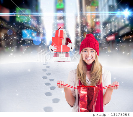 Composite image of pretty blonde opening gift bag 13278568