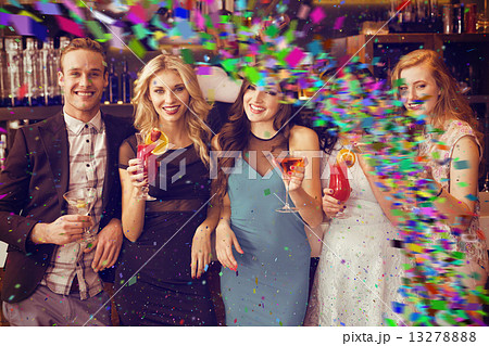 Composite image of attractive friends drinking cocktails togethe 13278888