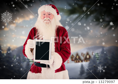Composite image of santa presents a tablet pc 13279097