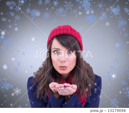 Composite image of festive brunette blowing over hands 13279098