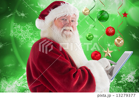 Composite image of santa uses a tablet pc and smiles into the camera 13279377