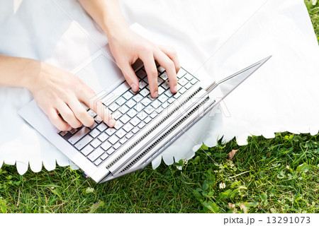 young man working in the park with a laptop 13291073