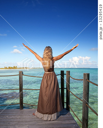 The young beautiful woman on a wooden platform over the sea The young beautiful woman on a wooden platform over the sea 13295419