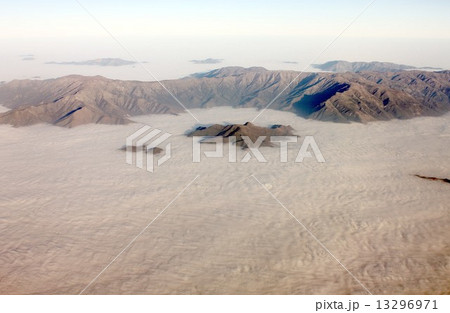 南米大陸を南北に縦断するアンデス山脈、快晴の冬空のもと朝霧の雲海の中から美しさと厳しい冬の自然の姿を現したチリ領内の山並み 南米大陸を南北に縦断するアンデス山脈、快晴の冬空のもと朝霧の雲海の中から美しさと厳しい冬の自然の姿を現したチリ領内の山並み 13296971