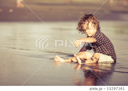 little boy playing on the beach at the day time 13297161