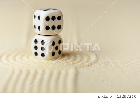 Two white dice with black dots on sand Two white dice with black dots on sand 13297250