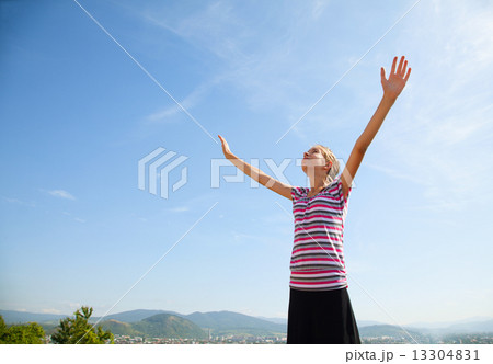 Teenage girl staying with raised hands 13304831
