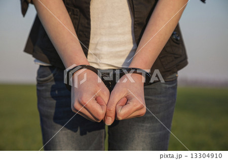 Handcuffed woman's hands 13304910