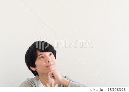 首を傾げる青年の写真素材