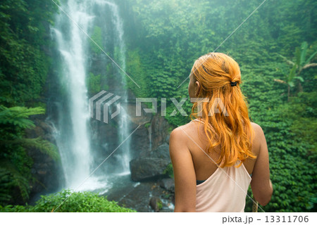 Female adventurer looking at waterfall 13311706